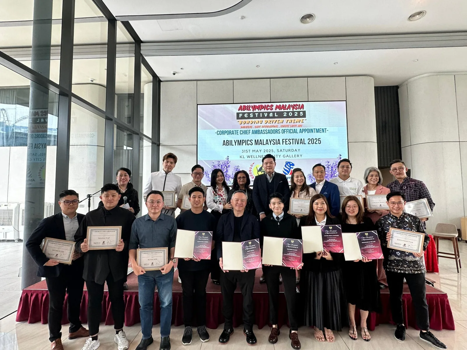 Corporate Chief Ambassadors holding appointment certificates at the Abilympics Malaysia Festival 2025 launch.