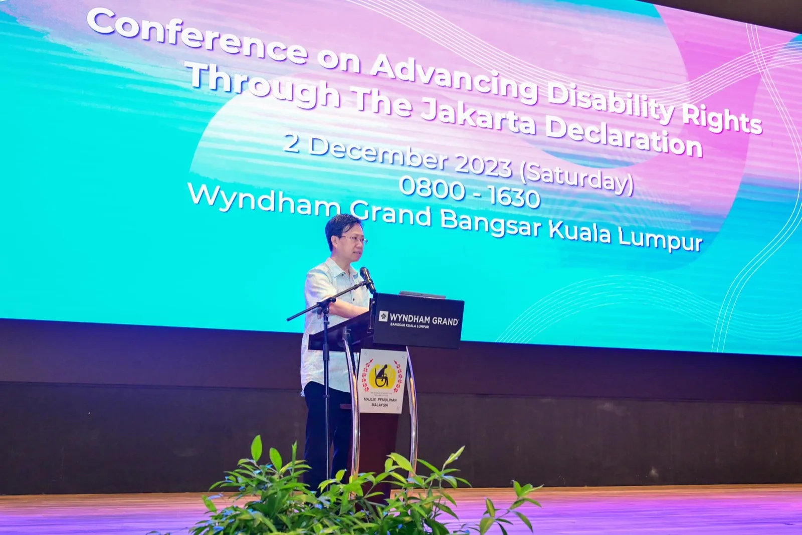 A speaker at the MCR rostrum in front of the Jakarta Declaration conference screen, Wyndham Grand Bangsar Kuala Lumpur, 2 December 2023.