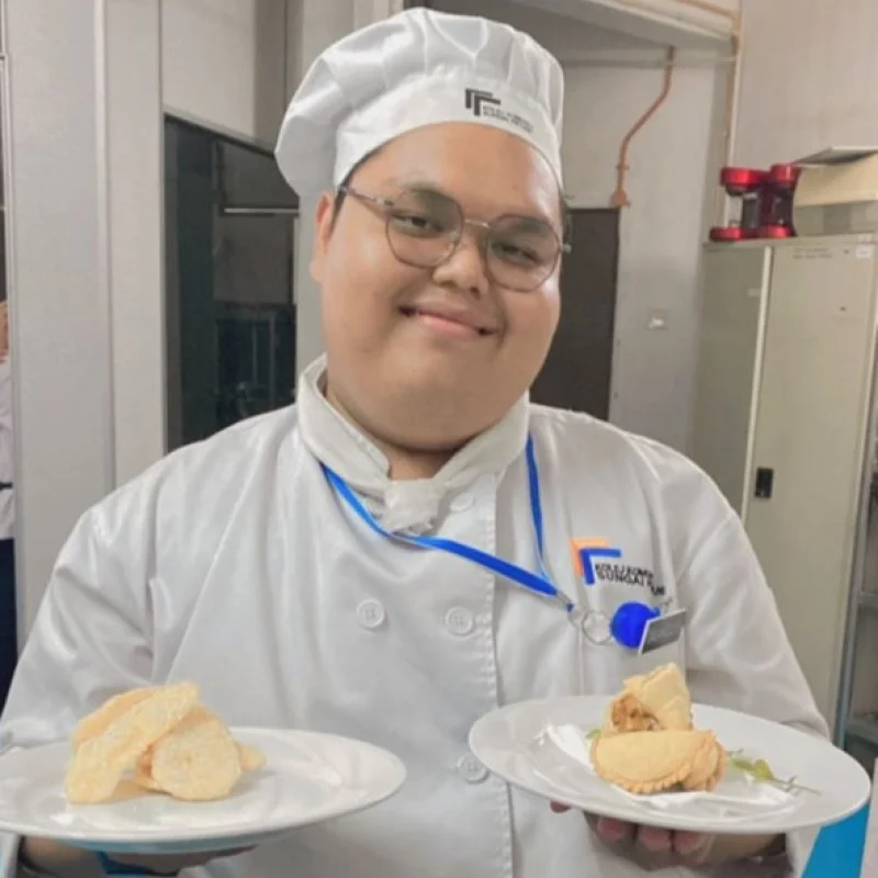 Malaysian competitor demonstrating cake decoration skill at Abilympics.